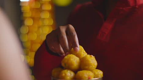 Close-Up-Of-Man-Giving-Ladoo-To-Woman-To-Eat-Celebrating-Festival-Of-Diwali